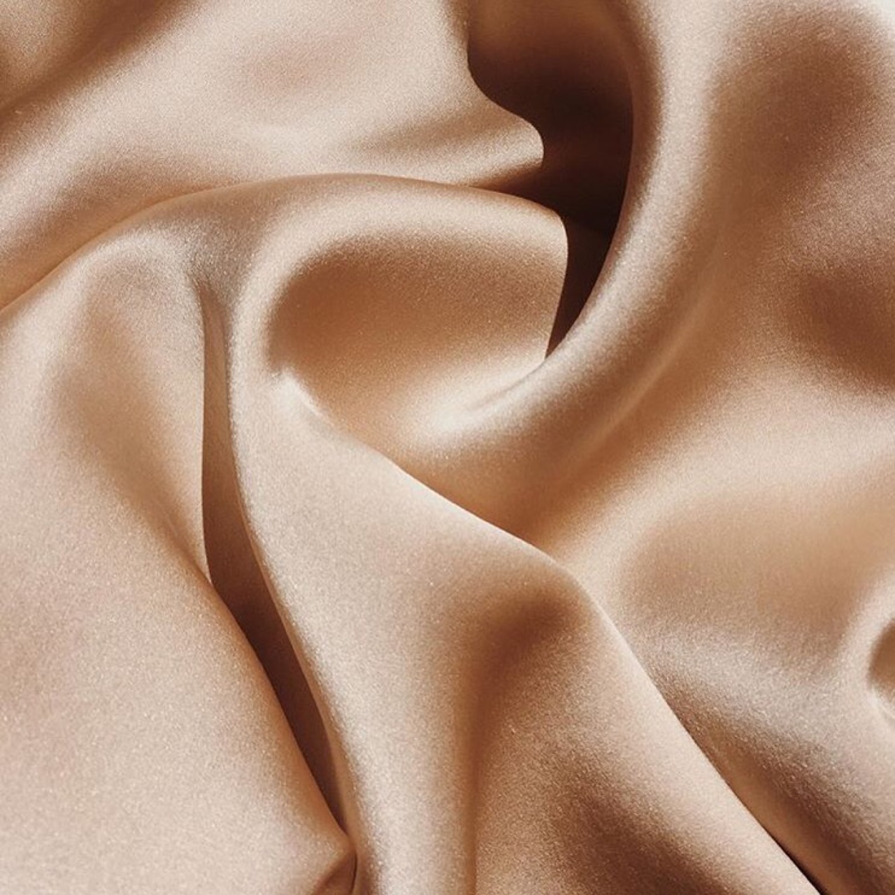 Shiny, smooth taupe colored fabric slightly wrinkled