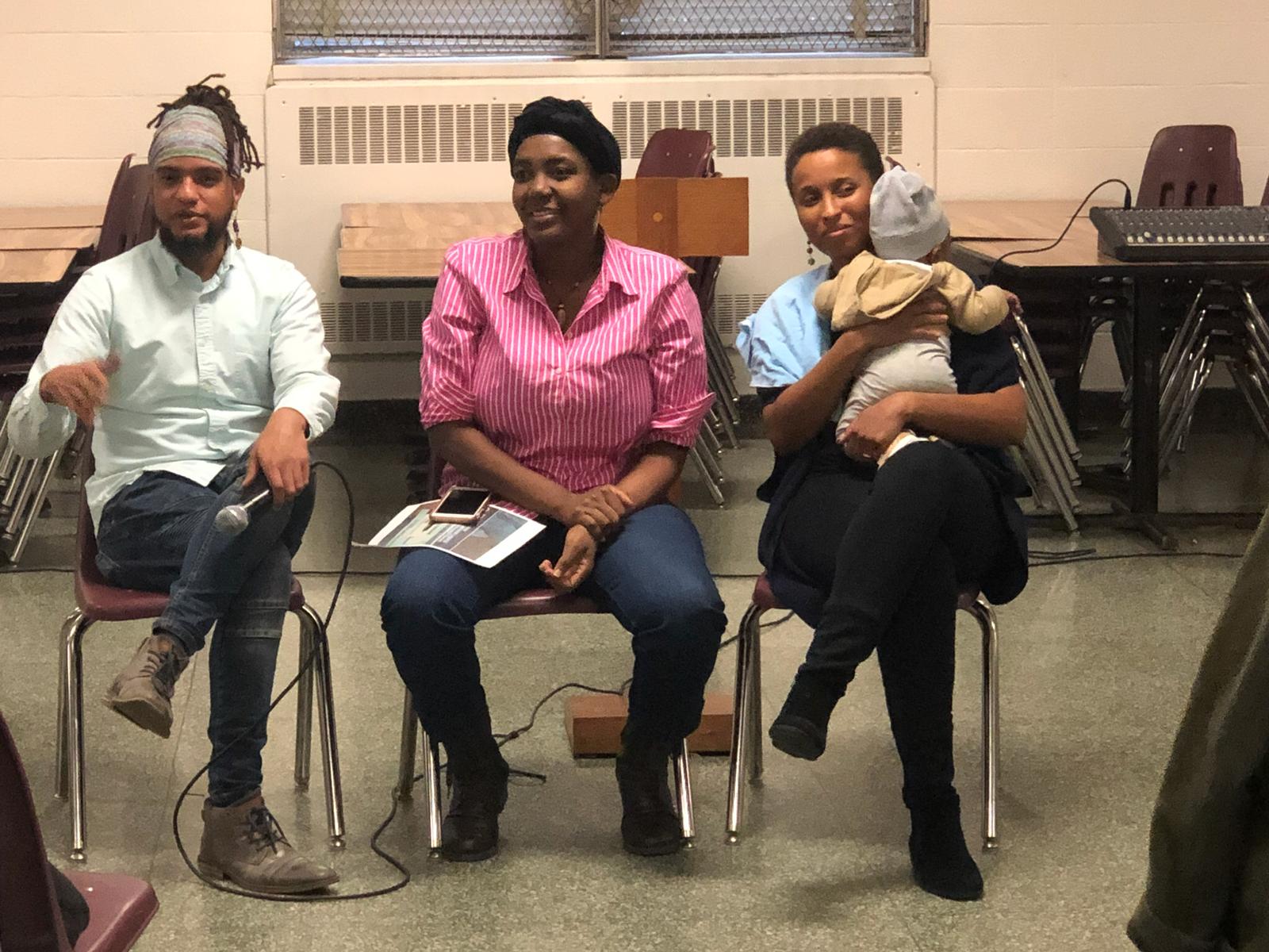Alexis Francisco, Altagracia Jean Joseph, and Miriam Neptune seated in a row as they facilitate the conversation. Miriam is holding a baby.