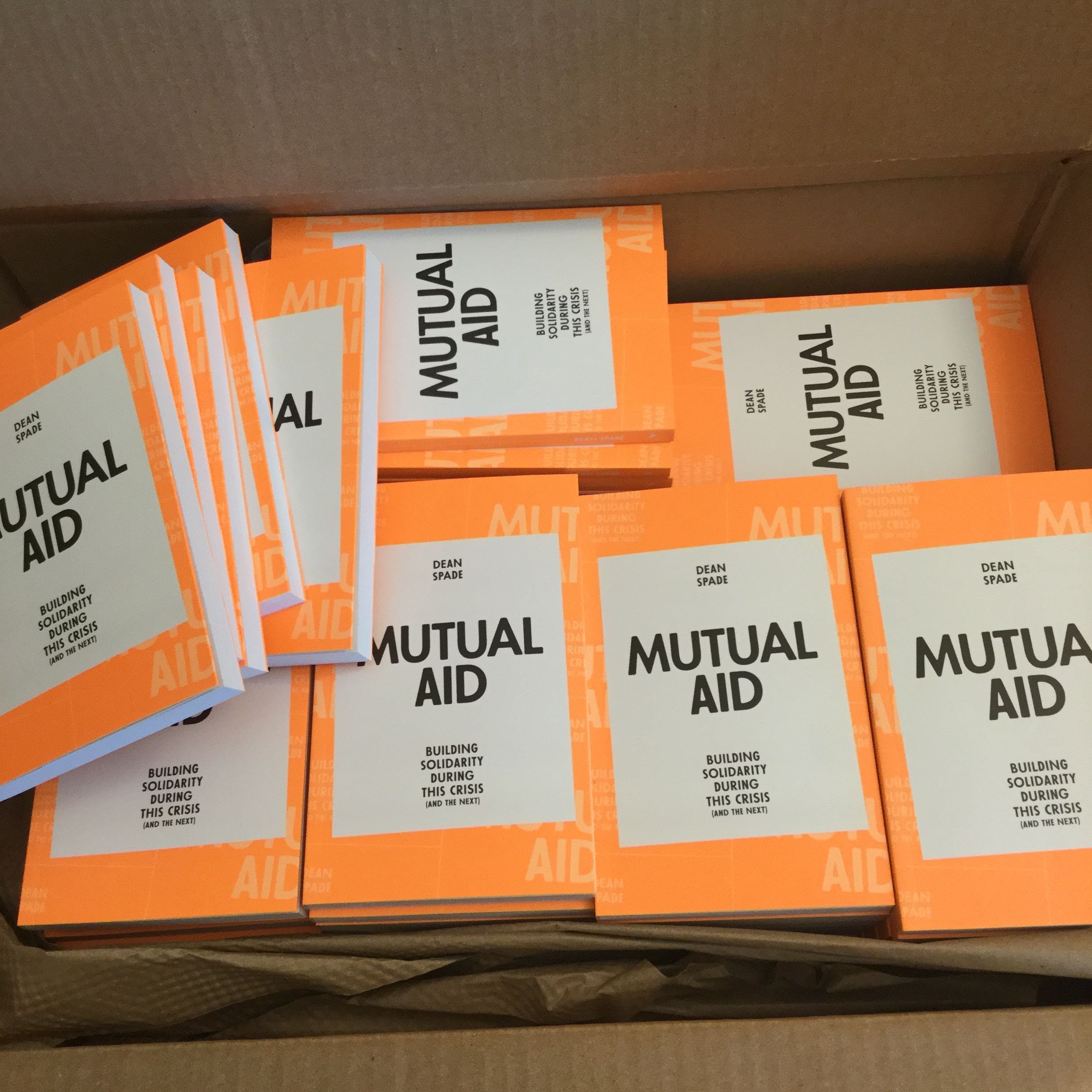 box full of copies of the book Mutual Aid