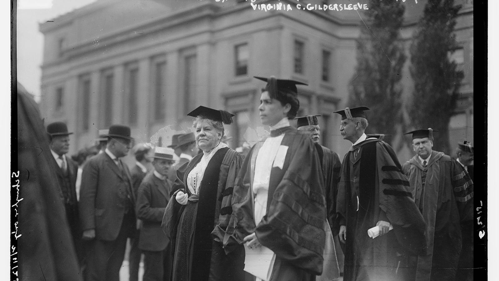 Gildersleeve stands with other faculty and administration members during a Columbia commencement event. Low Library can be seen in the background 