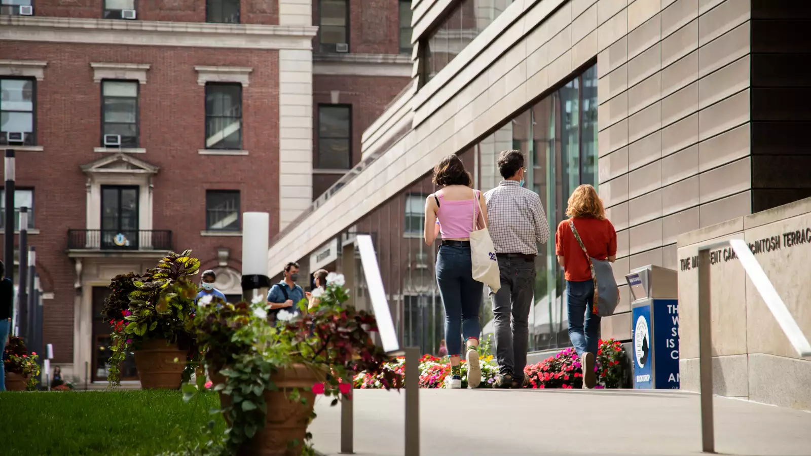 A Barnard student and family walking across campus.