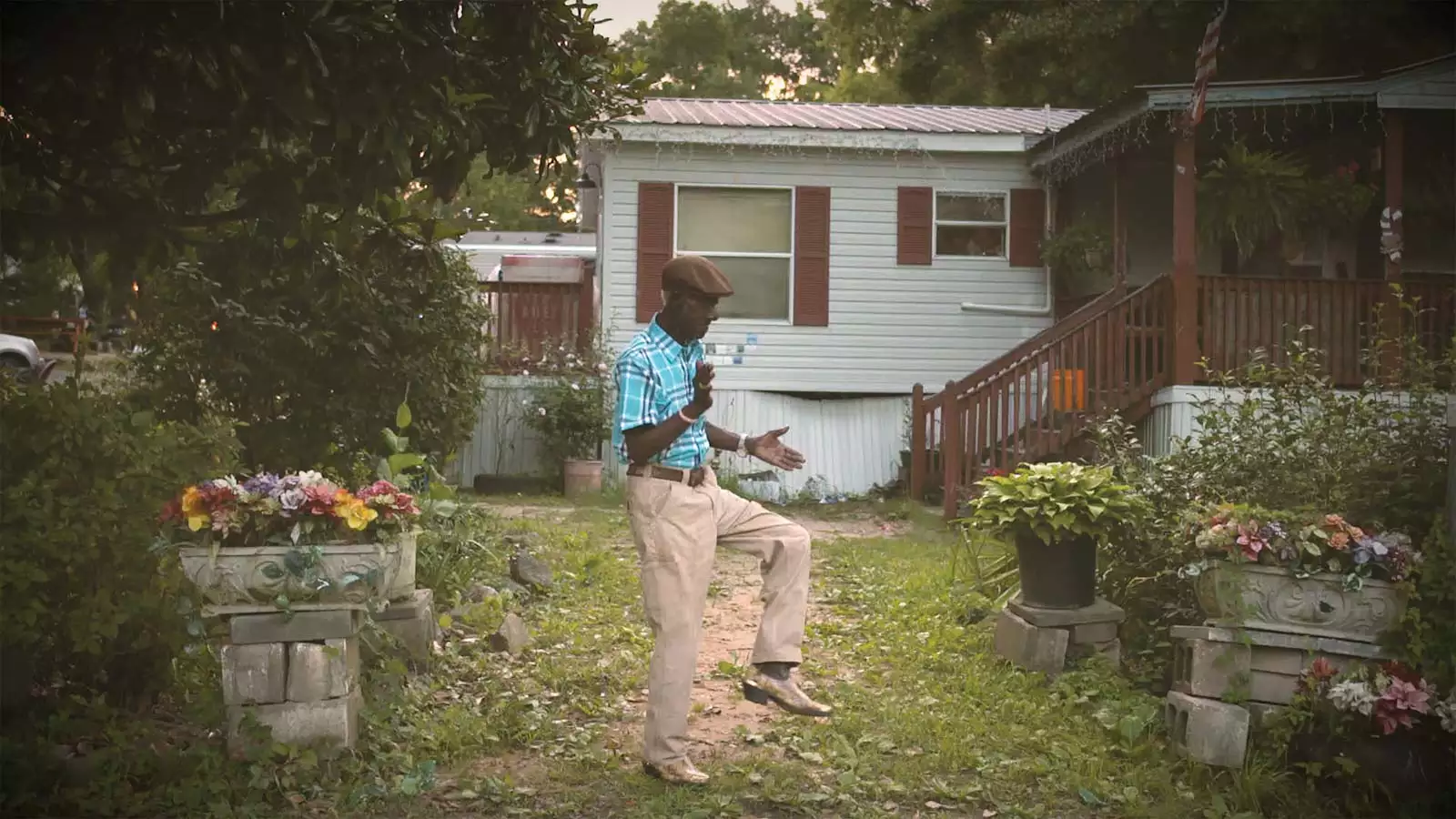 Black man in a grassy yard claps