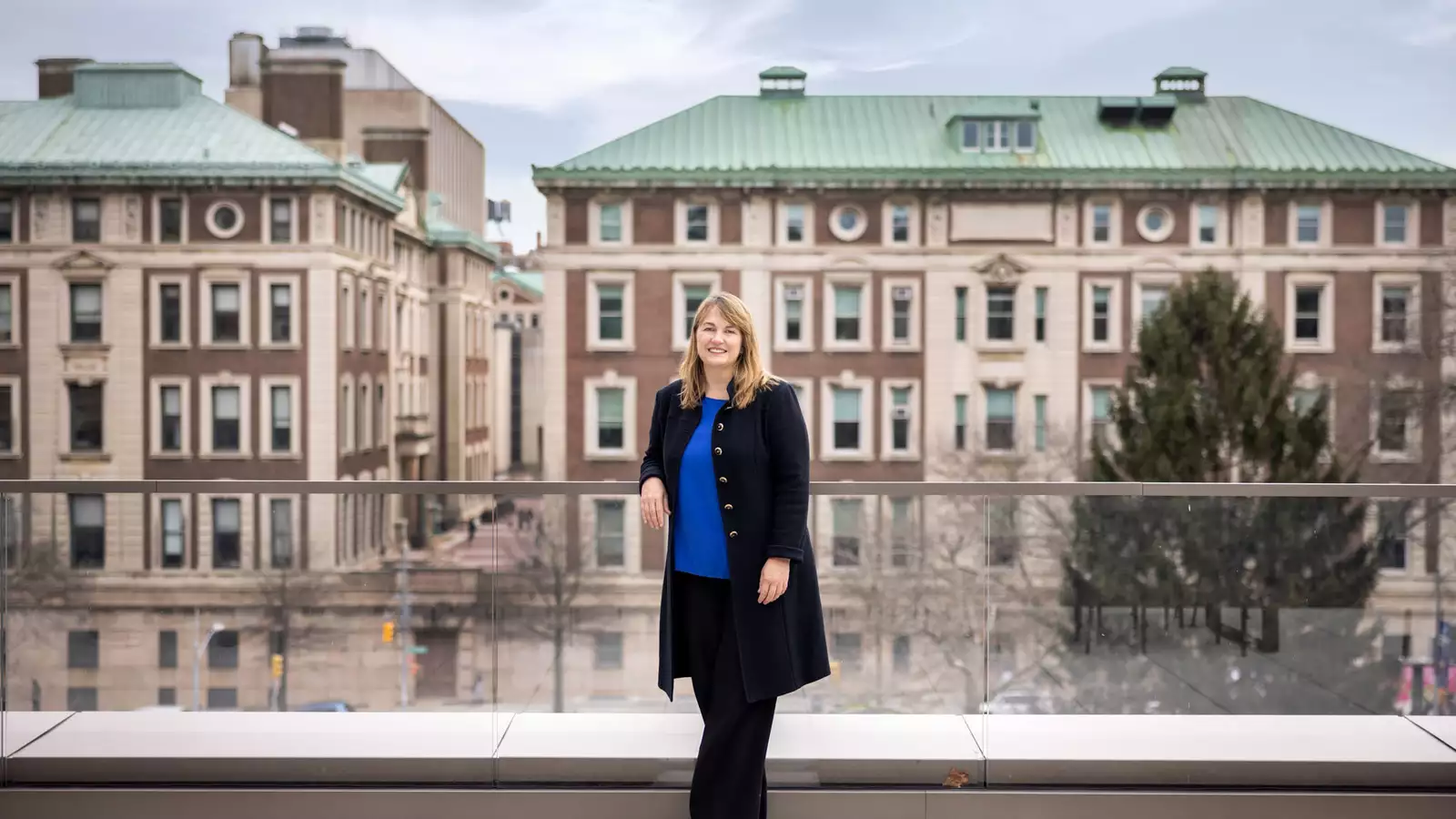 Laura Rosenbury standing with wideshot of campus behind her