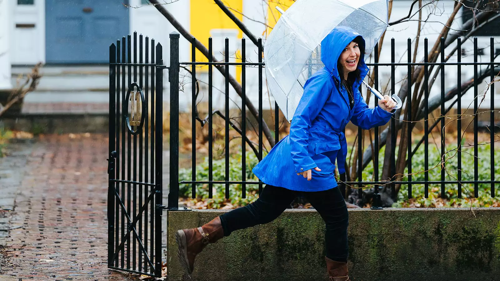 Sarah B. Miller skips in rain with umbrella