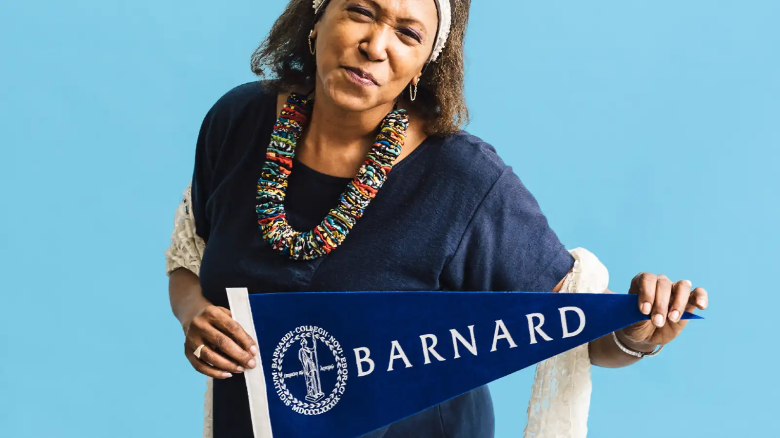 Black woman holding a Barnard pennant on the summer 2020 cover of Barnard Magazine