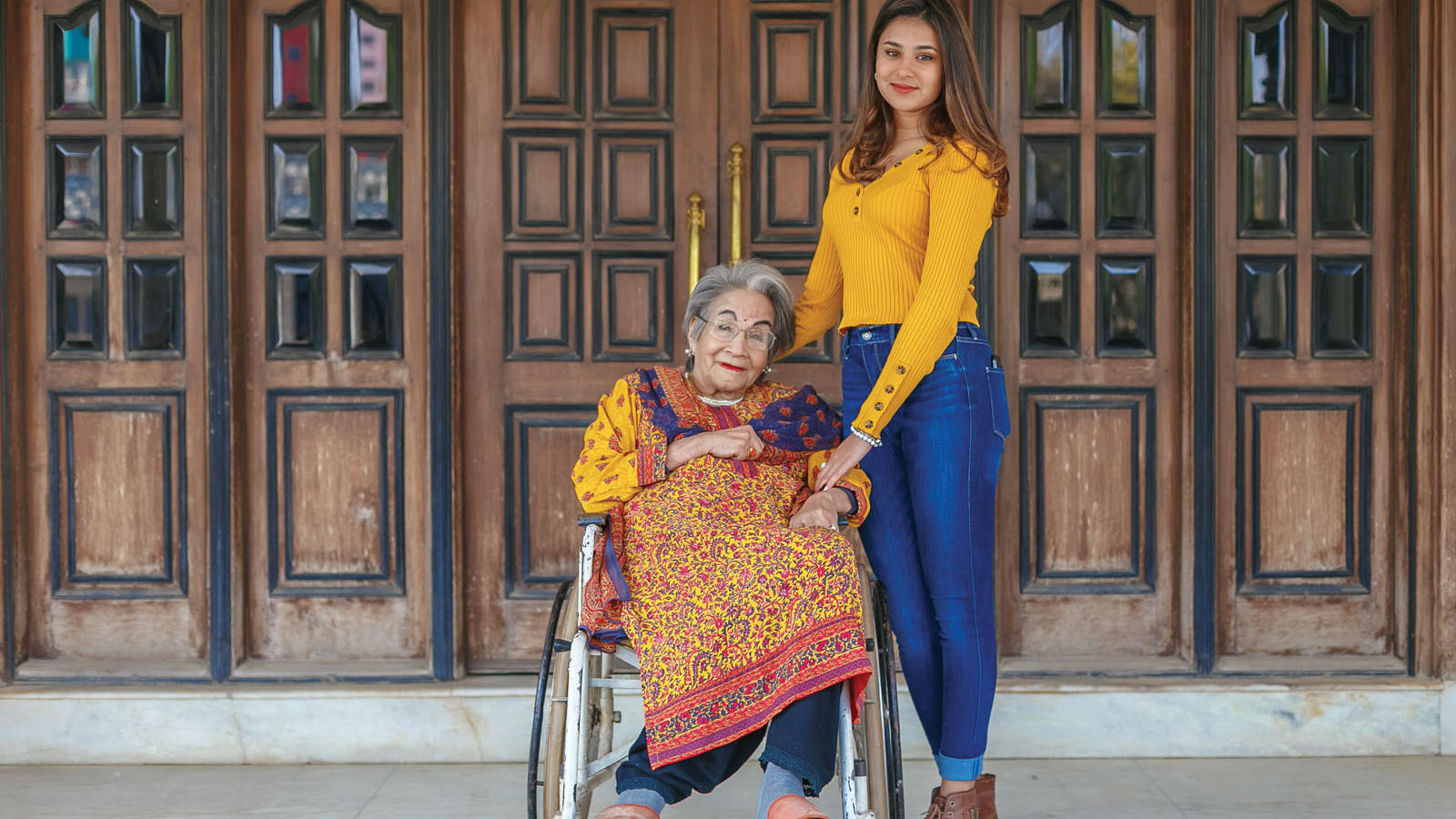 Bhinda Malla Shah '56 in a wheelchair next to her granddaughter Aarya Shah '23.