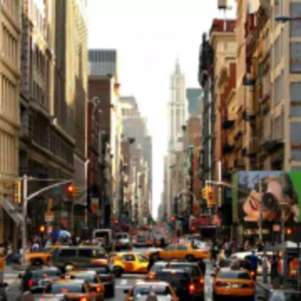 A New York street with tall buildings on each side and lots of traffic