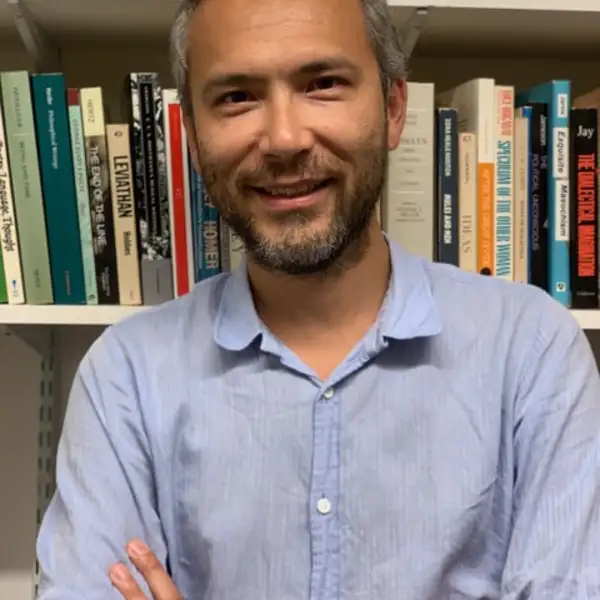 an image of Andrew Lynn in front of a bookcase