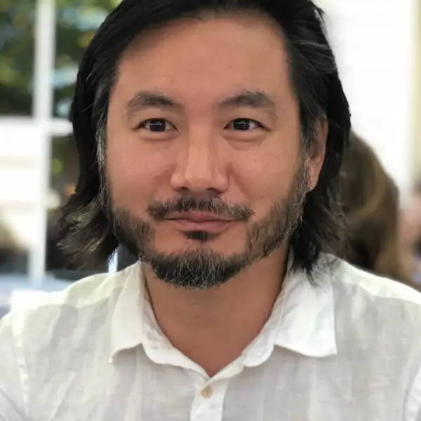 Image of an Asian man with shoulder length hair: Ken Chen, Associate Director of Creative Writing