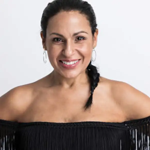 Female with Black fringe top, hair pulled back in ponytail braid on a white background. 