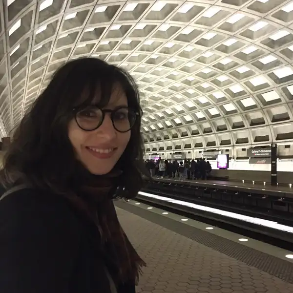 Image of Duygu smiling at a train station.
