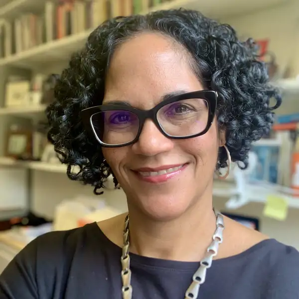 Monica L. Miller in front of bookshelves in her office.