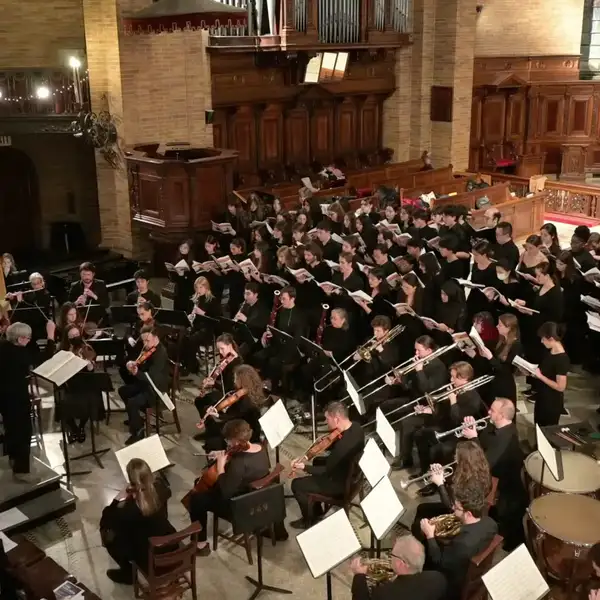 Professor Archer conducting a large orchestra 