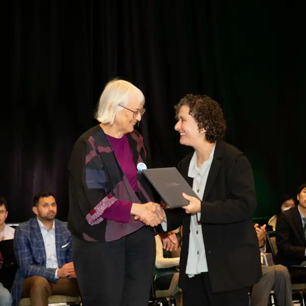 Dusa shaking hands during award