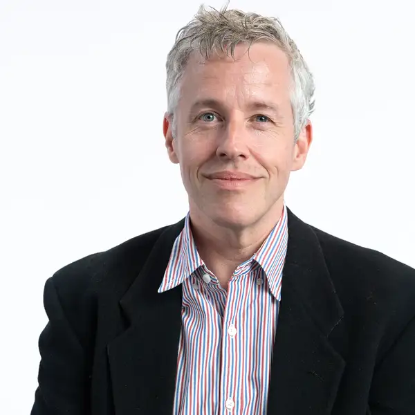 Headshot of professor in black suit with white background. 