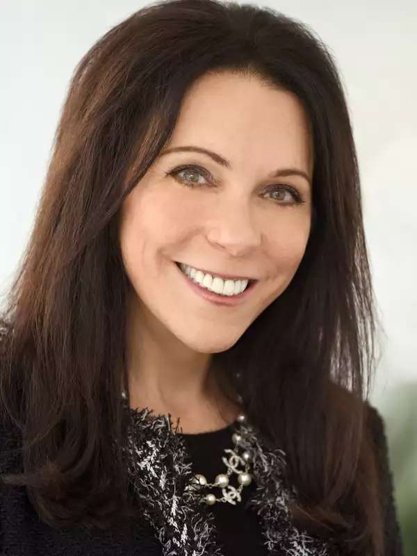 A white woman with brown hair smiling at the camera