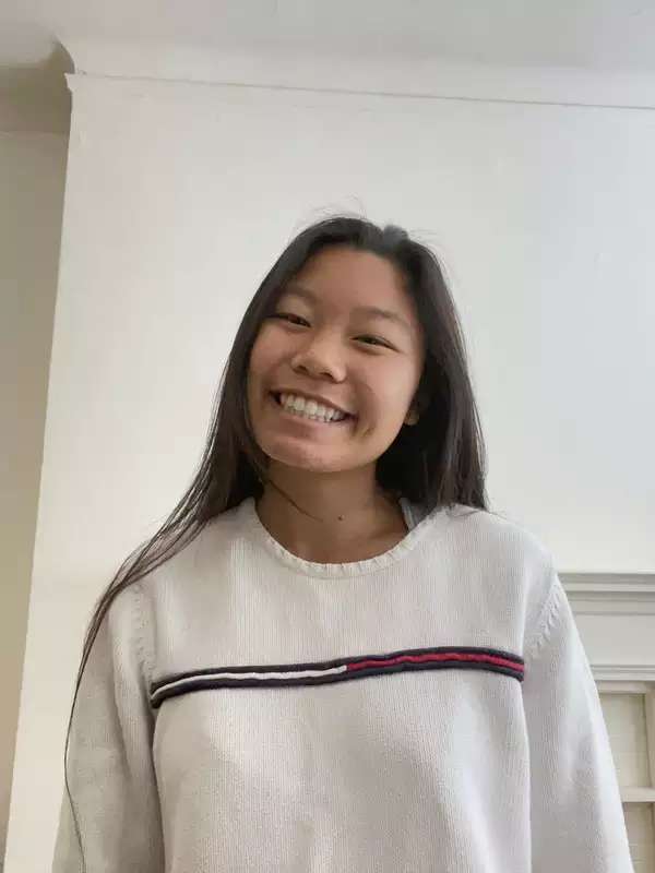 Katelyn is wearing a white shirt and smiling at the camera