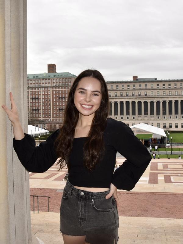 Image of Ariana posed near a pillar with Butler Library visible in the background