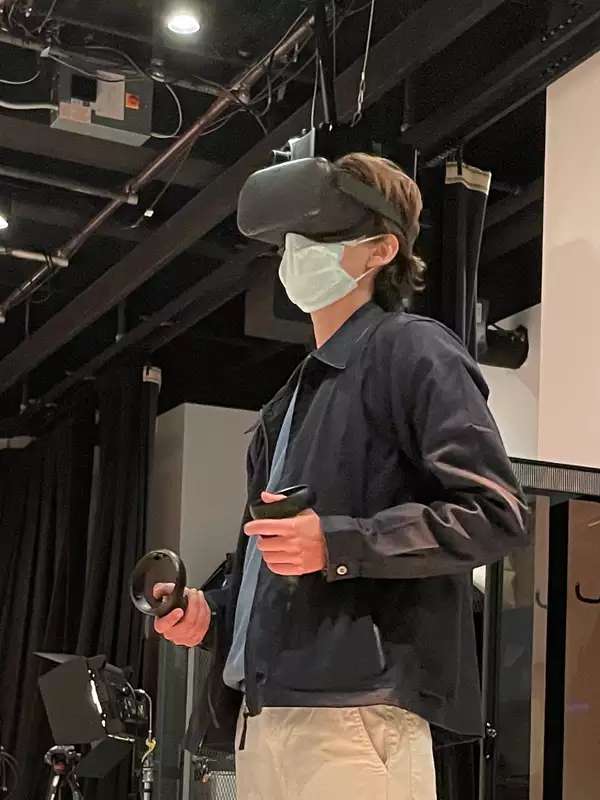 A photo of Eli Duncan standing in the Movement Lab using a VR headset