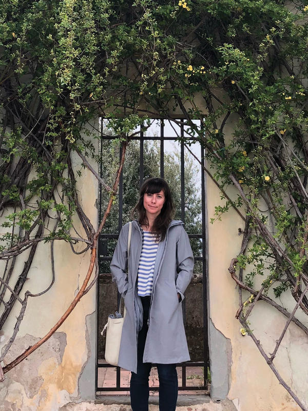 Nicole Anderson standing in front of wall with vines and leaves on it