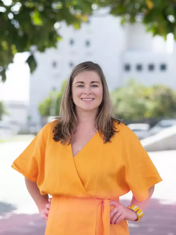 Headshot of professor in orange clothing