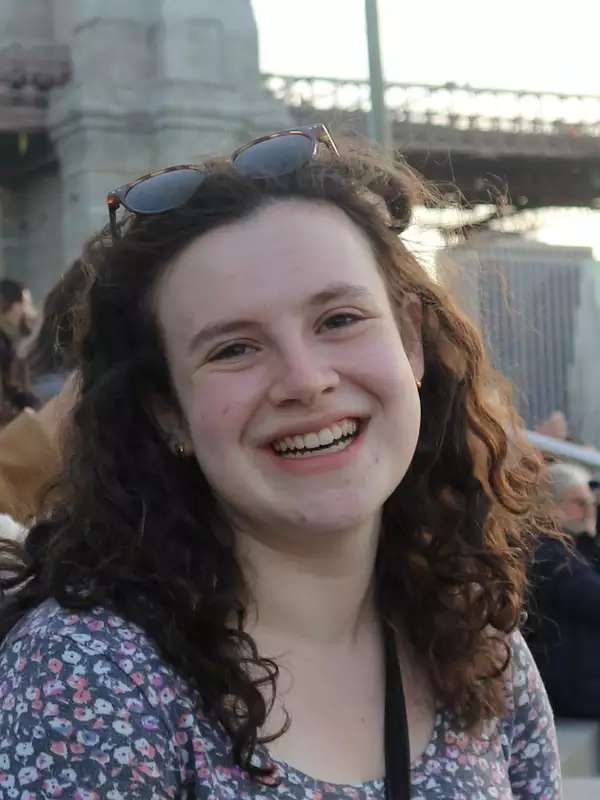 Lindsey Weiskopf wearing a floral shirt and sunglasses on her head outside.