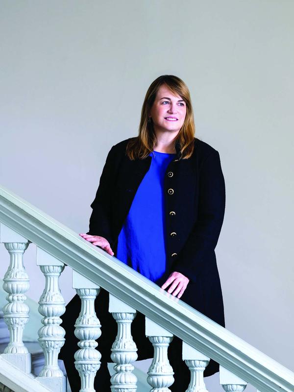President Laura A. Rosenbury standing on a white staircase