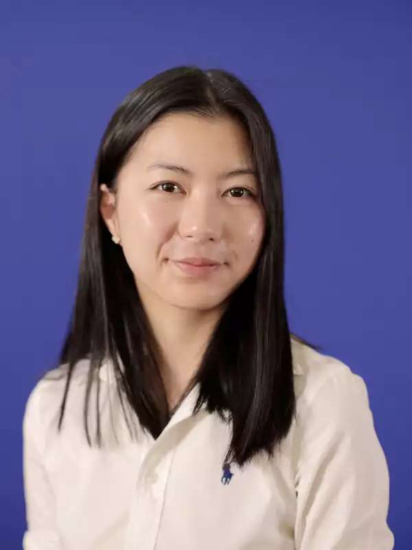 Woman with medium length dark hair, wearing light-colored button-down