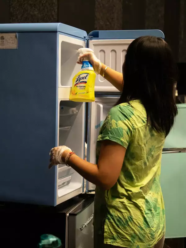 Student cleaning fridge