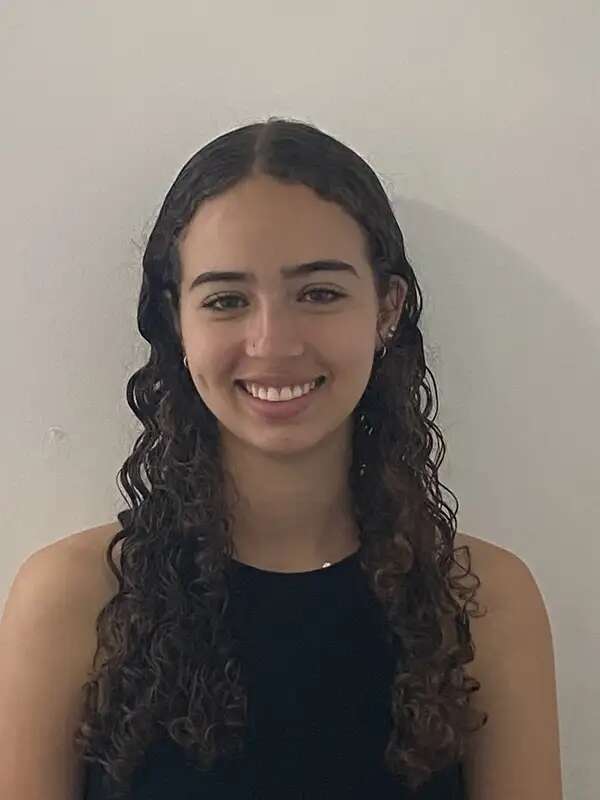 Photo of girl with curly hair smiling at the camera