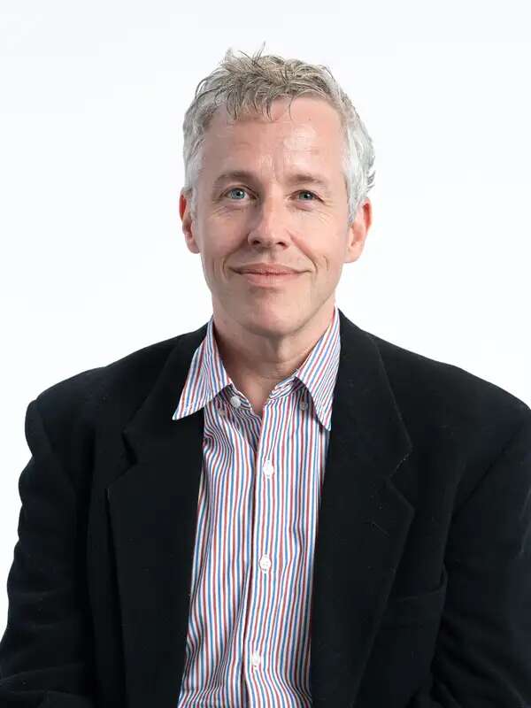 Photo of Andrew Lipman, a man with gray hair in striped shirt and a black blazer