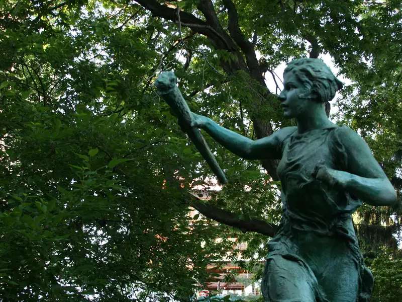 Spirit of the Greek games statue with trees in the background