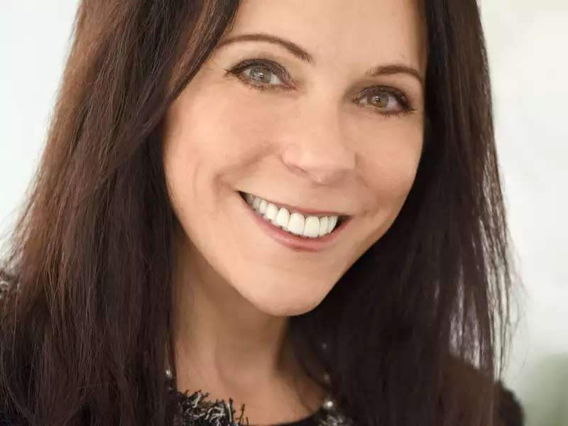 A white woman with brown hair smiling at the camera