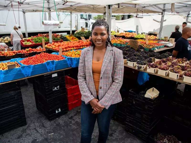 Olivia Watkins stands at a food stand 