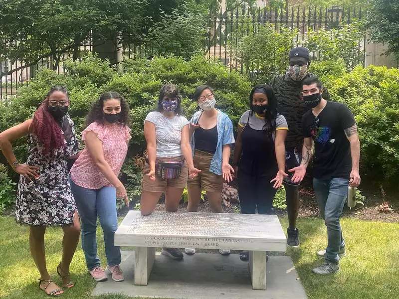 STEAM in the City teachers pose in front of a bench on campus during their summer institute.