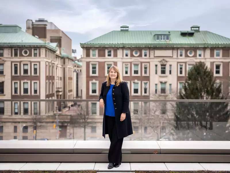 Laura Rosenbury standing with wideshot of campus behind her