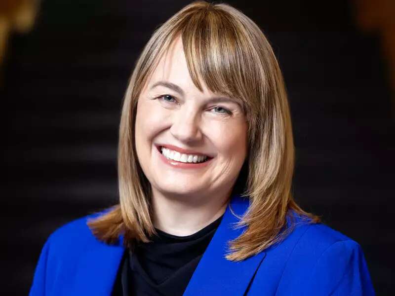 Laura Rosenbury wearing a bright blue blazer, smiling