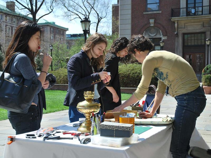 4 students around a table set up outside on a spring day