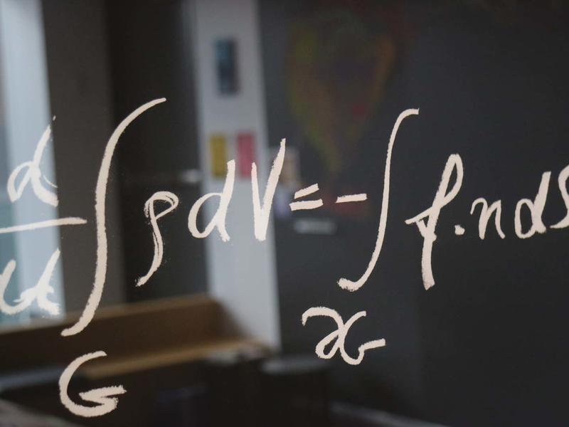 formula written on a glass wall of a classroom