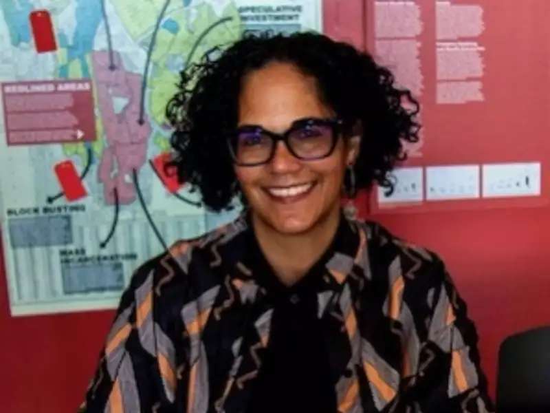 Photo of Prof. Monica Miller sitting at a desk