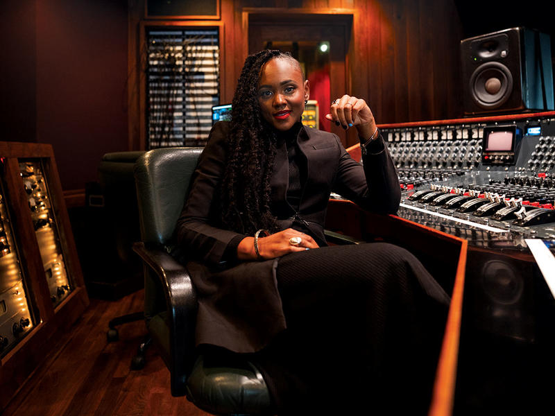 Ebonie Smith sits at music control panel 