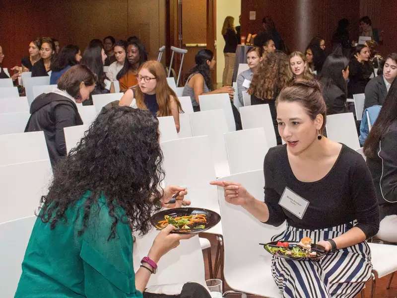 Pairs of alumnae mentors and current students eating lunch and talking