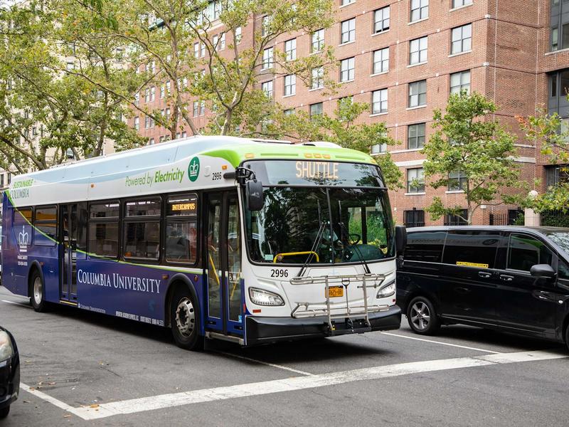 An electric shuttle bus on the street with Columbia University on it