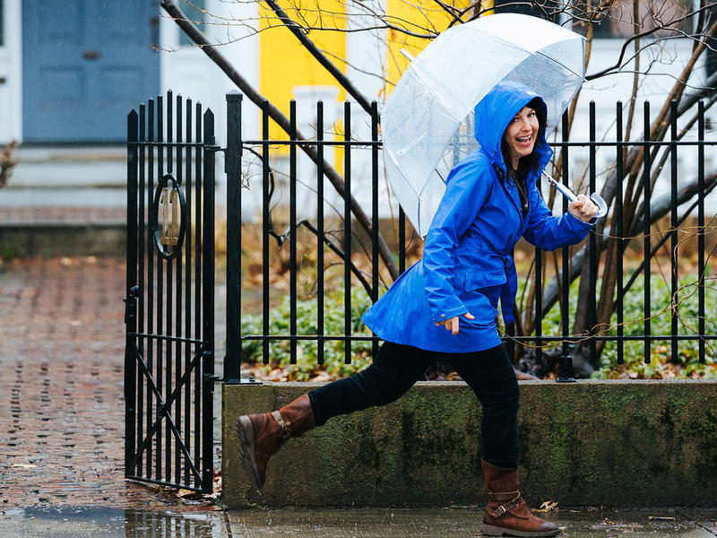 Sarah B. Miller skips in rain with umbrella