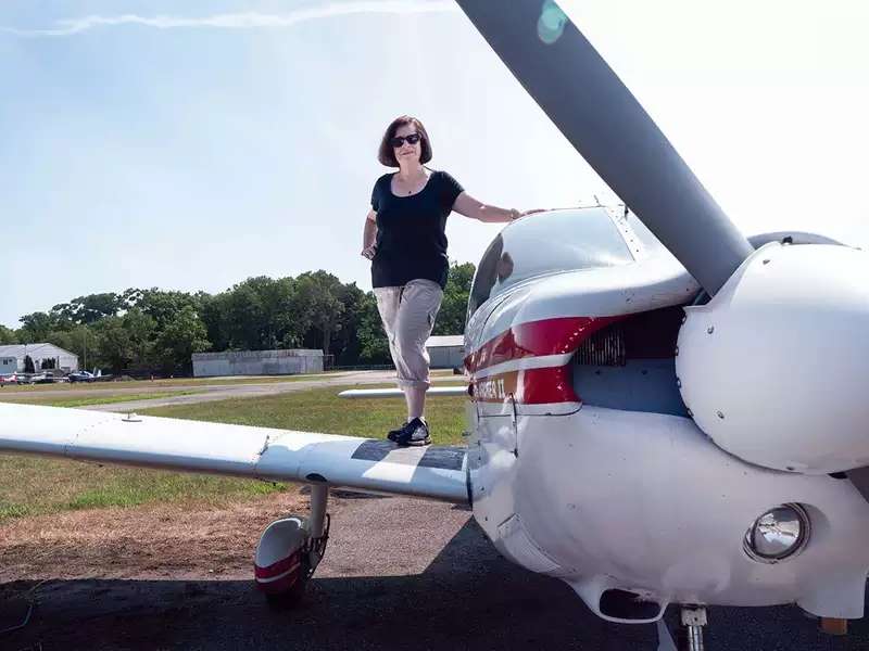 Beverly Weintraub stands on the wing of her small plane