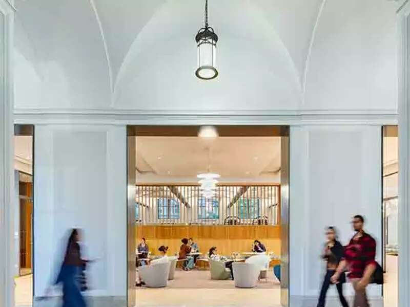 Francine LeFrak Center lobby, an airy space with light-green and blue furniture, with people strolling by