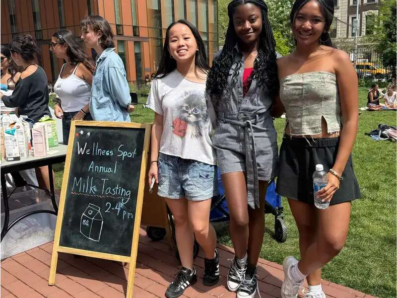 Students standing next to a sign for the 2025 Wellness Spot annual milk tasting event