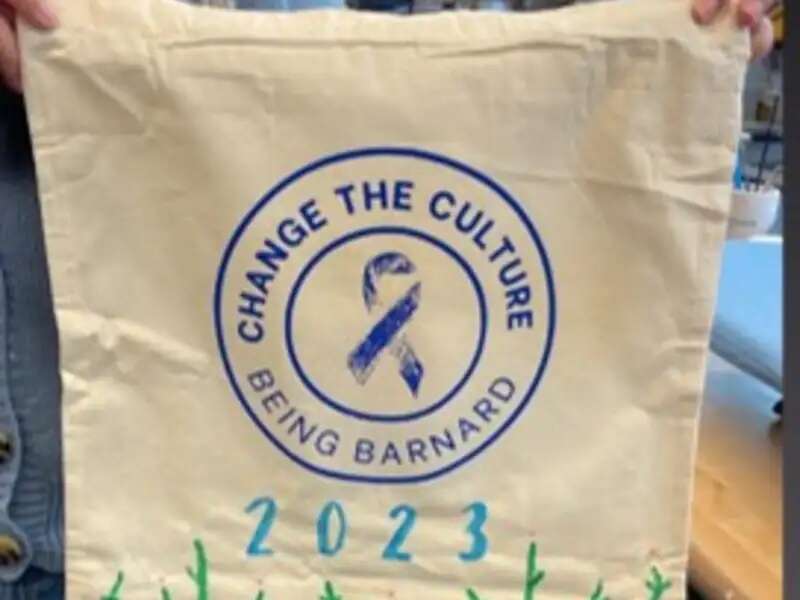 Student holding DIY tote bag that says change the culture