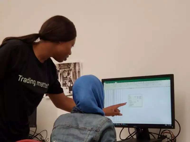 A student points at a computer screen to show another student
