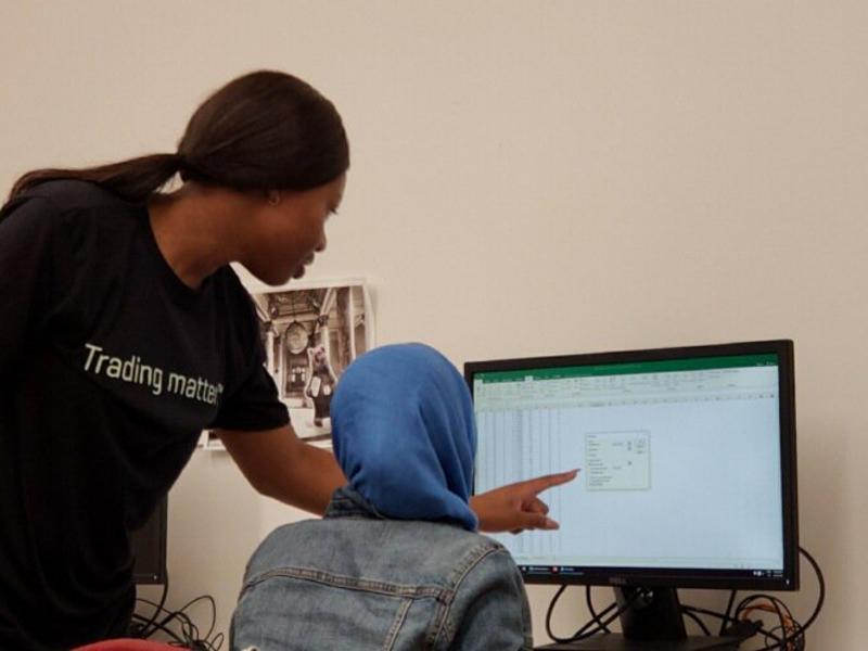 A student points at a computer screen to show another student